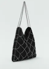 Bolso negro pequeño de fiesta con tejido de guipur, asa corta de cadena y cadenas decorativas.