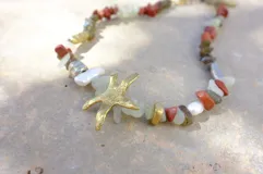 Collar de alpaca con cuentas de labradorita, jaspe rojo y cuarzo lima. Incluye una estrella de mar realizada a mano y una perla de río natural.