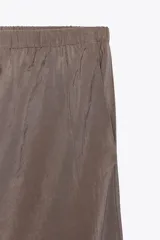 Pantalón palazzo color gris topo de tejido fluido, con cintura elástica ajustable con cordones y bolsillos laterales.