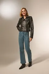 Chaqueta corta de eco cuero negra con tachas plateadas, cuello camisero y cierre frontal con cremallera.