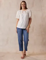Blusa color crema de crepe con detalle de crochet en el escote, mangas cortas amplias.