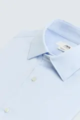 Camisa celeste de corte regular, con cuello italiano, mangas largas con puños abotonados y cierre frontal con botones.