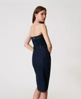 Vestido midi de jean azul oscuro, corte recto, sin mangas y con escote recto. Presenta cierre frontal con cremallera metálica, cinturón con hebilla forrada y abertura en el centro.