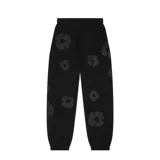 Pantalón de jogging negro con estampado de flores grises, corte holgado y cintura con cordón ajustable.
