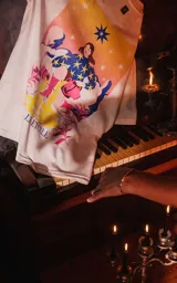 Remera blanca de algodón con cuello redondo y calce oversize. Estampa sublimada con diseño de tarot con una mujer, estrellas y plantas.