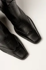 Bota corta de cuero sintético color blanco, estilo texana con bordados decorativos y taco cubano negro.