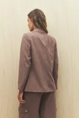 Blazer color beige de corte clásico en tela jaspeada, suave al tacto, liviana y con caída relajada.