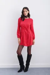 Vestido corto rojo con estampado floral, escote redondo, mangas largas con elástico en los puños, detalle de nudo drapeado en la cintura y escote en V pronunciado en la espalda.