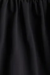Top corto negro de breteles finos, con escote recto y bajo globo.