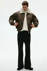 Buzo de punto color crema, con cuello alto y medio cierre metálico. Presenta un tejido acanalado en el cuello y un calce regular.