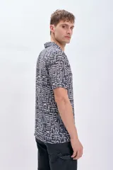 Camisa casual de viscosa con estampado geométrico en tonos blanco y negro, de manga corta y cuello americano.