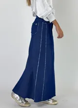 Pollera larga de denim color tostado con detalles de costura blanca y corte asimétrico.