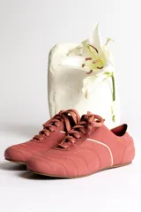 Zapatillas acordonadas color beige con detalles en blanco.