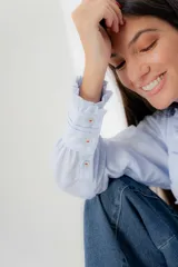Blusa blanca con detalles de fruncido y botones delanteros, de corte holgado.