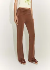 Pantalón marrón de tejido fluido con detalle drapeado en la cintura, diseño acampanado y estilo flare.