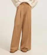 Pantalón pantalona de sastrería color beige, con trabillas en la cintura y pliegues delanteros.