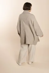 Saco de lana color marrón claro, con mangas amplias, cuello tipo bufanda con flecos y bolsillos laterales. Diseño oversize sin forro.