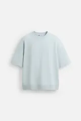 Sudadera relaxed fit color crudo confeccionada en tejido interlock de algodón con elasticidad, cuello redondo, manga corta y bajo acabado en rib.
