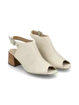 Sandalia peep toe color blanco hueso, confeccionada en cuero, con taco de madera y hebilla metálica.