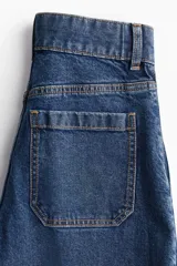 Jeans de pierna ancha en denim de algodón con leve stretch, tiro alto, corte holgado de muslo a bajo, largo cropped y bolsillos de parche atrás.