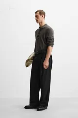 Polo de hombre color gris oscuro, de punto ligero tejido en hilatura con mezcla de seda y algodón. Tiene cuello solapa con cierre frontal de botonadura, manga larga y acabados en rib.