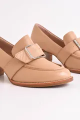 Mocasín de cuero color marrón con hebilla metálica plateada y taco de madera.