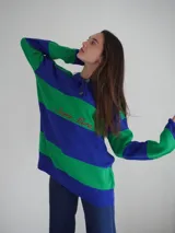 Sweater de hilo de algodón a rayas horizontales rosas y grises, con cuello polo, botones de guampa y bordado de Sierra Mora a tono.