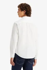Camisa blanca de manga larga con botones y bolsillo en el pecho.
