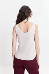 Musculosa de punto color blanco hueso, con escote en V tanto en el frente como en la espalda, y un calce ligero.