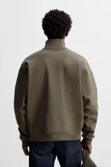 Sudadera negra de algodón con cuello alto y cierre de cremallera frontal. Corte relaxed fit, manga larga y terminaciones en rib.