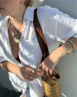 Collar con dije grande de bronce con forma de ostra y cordón de algodón ajustable color gris.