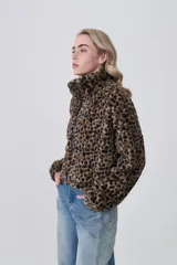 Campera corta de tejido peluche (corderito) con cierre frontal y cuello camisero. Presenta un estampado animal print de cebra o tigre en tonos marrón claro y negro.