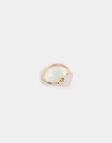 Anillo dorado con forma de corazón con textura rosa pálido.