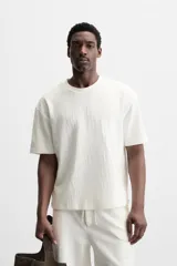 Camiseta negra de corte holgado, con cuello redondo y mangas cortas.