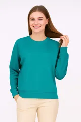 Buzo holgado color verde azulado, con cuello redondo y mangas largas.