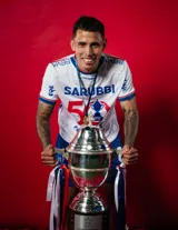 Camiseta de fútbol Umbro del Club Nacional de Football, modelo Home 2025. Diseño blanco con detalles en azul y rojo en cuello y mangas. Incluye logo de Umbro, escudo del club y sponsor Sarubbi en el frente.