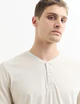 Remera manga corta con cuello redondo y tapeta con dos botones.