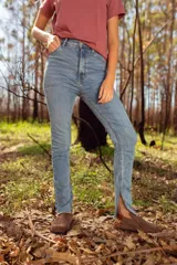 Pantalón de jean celeste, corte skinny, tiro alto y aberturas en el ruedo.