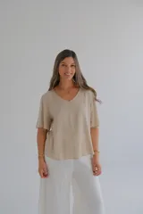 Blusa beige de mangas cortas con volados y escote en V.
