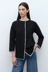 Saco de punto color ciruela oscuro, de manga larga y cuello redondo, con cierre frontal de botones y ribetes en contraste blanco con puntada decorativa.