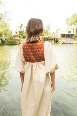 Túnica negra de lino con cuello cuadrado y mangas 3/4 abullonadas con elástico en los puños. Presenta apliques de textiles antiguos en la pechera delantera y trasera.