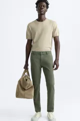 Pantalón chino azul marino, corte skinny fit, confeccionado en tejido de algodón con elasticidad. Cuenta con bolsillos frontales y traseros de vivo. Cierre frontal con cremallera y botón.