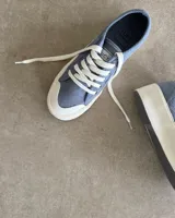 Zapatillas de lona celeste con cordones blancos y suela blanca.