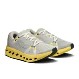 Championes de running On Cloudsurfer 2, color gris claro con detalles en amarillo y blanco.