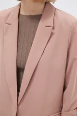 Blazer color rosa viejo, de corte recto, con solapas y mangas 3/4 con botón decorativo.