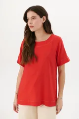 Blusa manga corta color rojo con cortes laterales y abertura abotonada en la espalda. Los pespuntes a contratono resaltan el escote y los cortes.