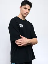 Remera negra de corte holgado con cuello redondo y logo de Umbro estampado en el pecho.