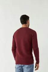 Sweater mostaza de punto con cuello redondo, mangas largas y logo bordado en el pecho. Corte slim fit.