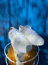 Zapatilla blanca de diseño minimalista, fabricada en 100% cuero.