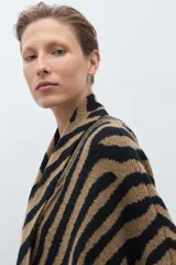 Ruana de punto jacquard con estampado animal print de cebra en colores negro y tostado, de diseño abierto y corte holgado.